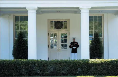  ?? THE ASSOCIATED PRESS ?? A Marine is posted outside the West Wing of the White House, signifying the President is in the Oval Office, Oct. 7, in Washington.