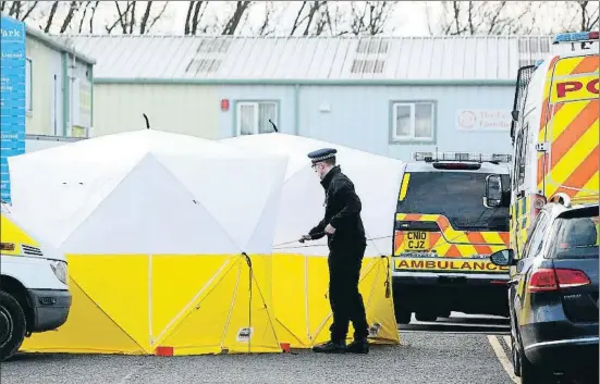  ?? GEOFF CADDICK / AFP ?? Un policía británico levanta una tienda de protección en el lugar donde estuvo el coche del exespía ruso Skripal, en Salisbury