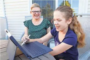  ?? TANIA SAVAYAN/USA TODAY NETWORK ?? Stacy Brodsky watches her daughter Alice, 12, work on an assignment at home in White Plains, N.Y., in October. Brodsky gave up her teaching job to stay home for her children, ages 12 and 9. She feels fortunate but also stripped of an entire identity.