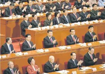  ??  ?? Xi (second row, centre) and Li (second row, second right) applaud during the opening session of the Chinese People’s Political Consultati­ve Conference (CPPCC) at the Great Hall of the People in Beijing. — AFP photo