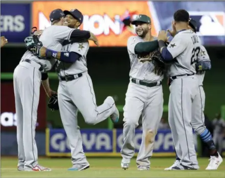  ?? LYNNE SLADKY — THE ASSOCIATED PRESS ?? American League’s Seattle Mariners Robinson Cano (22), second from left, is hugged by Cleveland Indians pitcher Andrew Miller, after winning the MLB baseball All-Star Game, Tuesday in Miami. Cano hit a home run in the tenth inning to win the game. The...