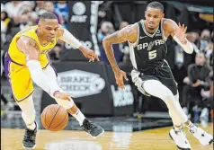  ?? Darren Abate The Associated Press ?? The Lakers’ Russell Westbrook, left, and the Spurs’ Dejounte Murray battle for the ball during the first half of the Lakers’ 125115 overtime victory at AT&T Center.