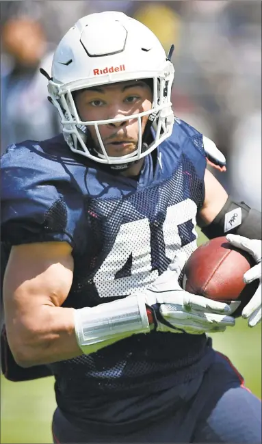  ?? Jessica Hill / Associated Press ?? UConn’s Donevin O'Reilly runs in for a touchdown during Saturday’s spring game in East Hartford.