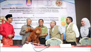  ??  ?? Dr Mahathir (second left) and Len Talif (third left) share a light moment as they hold a plush model of an orang utan during the symbolic handing over ceremony.