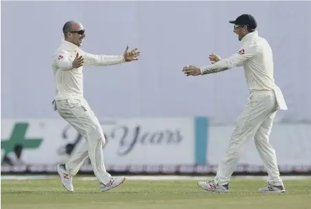  ??  ?? Jack Leach and Joss Buttler celebrate the dismissal of Sri Lanka’s Dilruwan Perera .