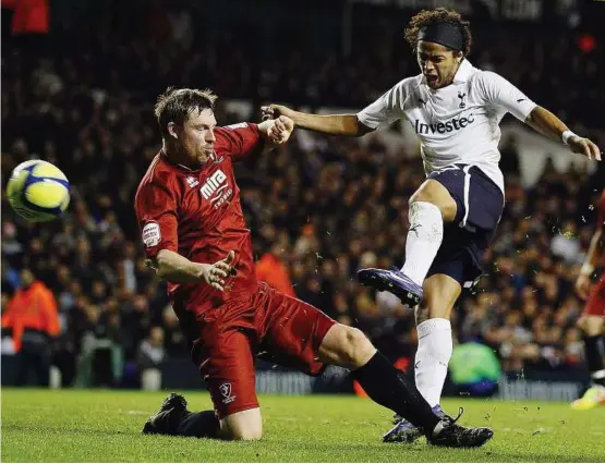  ??  ?? Lucky strike: Tottenham Hotspur’s Giovani dos Santos (right) scoring past Cheltenham Town’s Steve Elliot during the English FA Cup third round match at White Hart Lane on Saturday. — AP