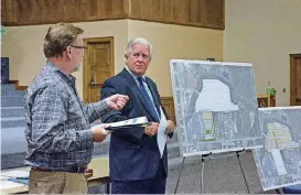  ?? [PHOTO BY ERIECH TAPIA, FOR THE OKLAHOMAN] ?? Terence Haynes, left, the engineer on the project, and Bob Rogers, the developer, discuss the Shops at Spring Creek project at a Community Connection meeting on Monday night in Edmond.
