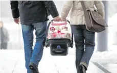  ?? FOTO: FRISO GENTSCH/DPA ?? Eltern tragen ihr neugeboren­es Baby aus der Klinik. Doch beim Elternsein sollten sie darauf achten, dass das Paarsein nicht zu kurz kommt.