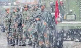  ?? AP PHOTO ?? Army personnel take position as it snows at the site where two gunmen opened fire near a paramilita­ry camp in Srinagar on Monday.