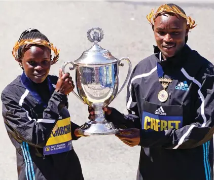  ?? ?? Boston Marathon women's division winner Peres Jepchirchi­r, of Kenya, left, and men's winner Evans Chebet, of Kenya, pose at the finish line Monday, April 18, 2022, in Boston.