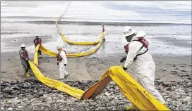  ?? AP ?? Workers prepare an oil containmen­t boom Thursday at Refugio State Beach, north of Goleta, Calif. More than 7,700 gallons of oil has been cleaned up from a spill that stretched along nine miles of California coast. The oil leaked form a broken pipeline.