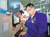  ??  ?? A technician with Shengrui Transmissi­on Co examines parts for the company’s 8AT product.