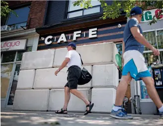 ??  ?? Cement blocks barricade the entrance to Cafe, a dispensary in Toronto shut down by police