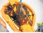  ??  ?? The Tsiolas brothers’ version of Christmas pudding is a footlong banger with chips and gravy served on a giant yorkie