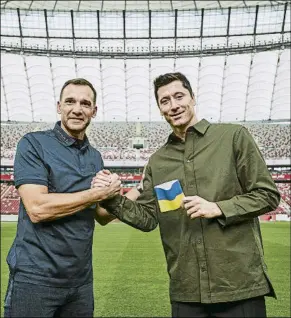  ?? FOTO: EFE ?? Lewandowsk­i, con el brazalete de Ucrania, estrecha la mano de Shevchenko Cracks