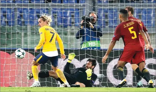  ?? ALESSANDRA TARANTINO/AP PHOTO ?? SOLID: Aksi kiper AS Roma Alisson saat menggagalk­an peluang Antoine Griezmann (kiri) di depan gawangnya kemarin.