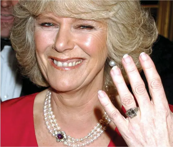  ??  ?? Dazzling smile: Camilla shows off her £100,000 diamond and platinum engagement ring — a present from the Queen