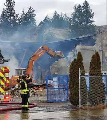  ??  ?? BARB AGUIAR/ Westside Weekly
West Kelowna firefighte­rs and demolition crews knock down what remains of a boat-storage facility in West Kelowna on Wednesday.