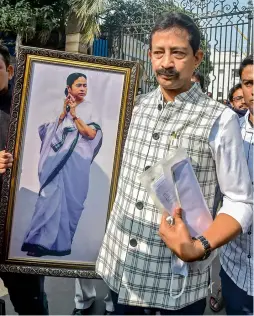  ?? — PTI ?? TMC leader Rajib Banerjee, who recently exited the West Bengal cabinet, carries a photograph of CM Mamata Banerjee after resigning from the post of MLA, in Kolkata on Friday.