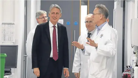  ?? Picture: PA. ?? Chancellor Philip Hammond is shown around a lab by Professor Paul Wyatt, right, at Dundee University’s School of Life Sciences during a whistlesto­p visit yesterday.