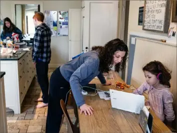  ?? Victor J. Blue/The New York Times ?? Jessica Haller helps her daughter Mattie, 7, with her homework Sunday at their home in the Riverdale neighborho­od of the Bronx. Ms. Haller is not under quarantine, but her four children are, which has led to confusion.