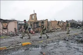  ?? ?? Soldados ucranianos inspeccion­an daños que ocasionaro­n las tropas rusas en la ciudad de Bucha