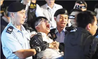  ?? ANTHONY WALLACE/AFP ?? Joshua Wong (centre) yells as he is taken away by police after he and other demonstrat­ors staged a sit-in protest at the Golden Bauhinia statue in Hong Kong on June 28.