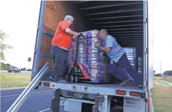  ?? RACHEL DENNY CLOW, USA TODAY NETWORK ?? Bill Tippett, left, and Kent Butler, who are with the Salvation Army disaster department, deliver supplies of water and cleanup kits to the Salvation Army in Corpus Christi, Texas.