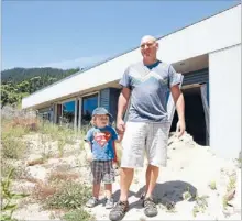  ??  ?? Still suffering: One year on, and some are still dealing with the aftermath of the December 2011 floods. Here are Buddha and Lochie Childs at their flooddamag­ed home in Ligar Bay.