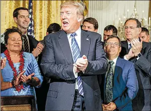  ?? AP/EVAN VUCCI ?? President Donald Trump applauds Friday at the White House after signing the Department of Veterans Affairs Accountabi­lity and Whistleblo­wer Protection Act of 2017. Arkansas Sens. Tom Cotton (back left) and John Boozman (applauding right) co-sponsored...