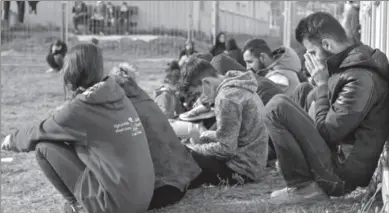  ?? ?? BERLIN
Migrants sit in front of containers at the Central Initial Reception Facility for Asylum Seekers, ZABH, in the federal German state of Brandenbur­g in Eisenhuett­enstadt, Germany. -REUTERS