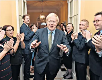  ??  ?? Harbinger of hope: Boris Johnson is applauded by Downing Street staff after his historic election victory