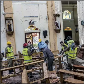  ?? The New York Times/ADAM DEAN ?? Investigat­ors in Negombo, Sri Lanka, on Monday study the scene of a suicide bombing at St. Sebastian Church.