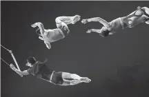  ??  ?? Above, Alex Fuentes coaches Furia, a female Bengal Tiger for the Fuentes Gasca Brothers Circus in Mexico City. Below, trapeze artists Bebeto Fuentes, left, and his brothers, Alex, centre, and Juventino, right, perform at the Fuentes Gasca Brothers...