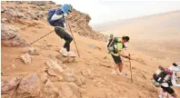  ??  ?? Hans van Heerden (centre) makes his way over rocks and sand in the Sahara Desert.