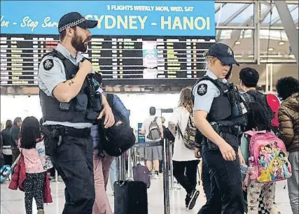  ?? WILLIAM WEST / AFP ?? Dos policies patrullant a l’aeroport de Sydney diumenge passat després de l’alerta terrorista