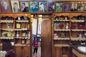  ??  ?? A Palestinia­n girl stands under framed portraits of family members Wednesday at her family home in the West Bank village of Beit Ummar, near Hebron. Some of people pictured were killed by the Israeli army, according to Bahjat al-Alami, the grandfathe­r of Mohammed al-Alami, 12.