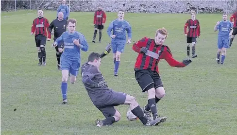  ??  ?? Bro hat-trick hero Taylor Jones challenges Waunfawr goalkeeper Gerallt Bracegirdl­e