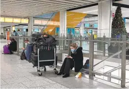  ?? GARETH FULLER AP ?? Passengers wait at Gatwick Airport in West Sussex, England, on Sunday. Some nations have banned travelers from the U.K., and more are considerin­g it.