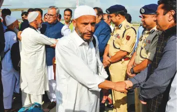  ?? AFP ?? Government officials welcome the first batch of Haj Muslim pilgrims at Srinagar Airport. Sround 300 pilgrims landed at the Srinagar airport yesterday morning.