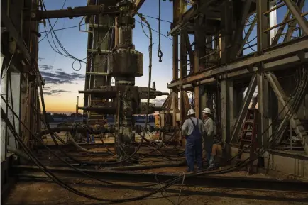  ?? Tamir Kalifa, © The New York Times Co. ?? Workers stand near a drill rig April 24 in the Permian Basin near Stanton, Texas. Oil prices have recovered spectacula­rly from their April plunge.