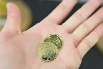  ??  ?? A PERSON holds visual representa­tions of the digital cryptocurr­ency Bitcoin, at La Maison du Bitcoin in Paris, Jan. 17.