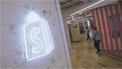  ?? Kevin Van Paasen / Bloombe
rgnews ?? The logo of Shopify Inc. hangs on a wall at the company’s office space in Toronto. Shopify raised US$131 million in an IPO
on Wednesday, watched closely by other marketing software firms such as Vision Critical Communicat­ions Inc.,