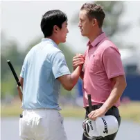  ?? AP ?? Michael Kim (left) and Andrew Putnam shake hands on the 18h green after completing the second round. —