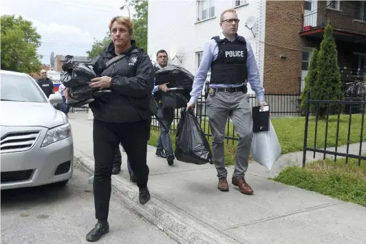  ??  ?? Cinq policiers ont quitté l’appartemen­t du suspect avec les mains remplies de sacs, de documents et d’au moins un ordinateur. PHOTO AGENCE QMI, MAXIME DELAND