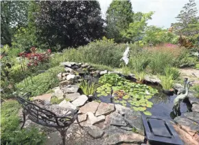  ?? MILWAUKEE JOURNAL SENTINEL ?? A waterfall and goldfish are among the featured areas in the garden of Patty Witt and her son Dave. The bench provides a quiet place to read.