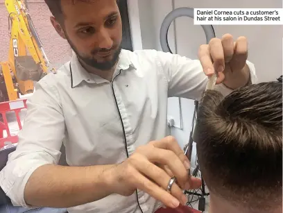  ?? ?? Daniel Cornea cuts a customer’s hair at his salon in Dundas Street