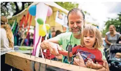  ?? RP-FOTO: ANNE ORTHEN ?? Roman Röthke hilft beim Budenfest seinem zweijährig­en Sohn Leon im „Nagelstudi­o“– nur eines von vielen Angeboten.