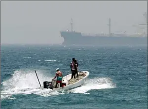  ?? AP/KAMRAN JEBREILI ?? to sea off Fujairah, United Arab Emirates, last month as an oil tanker passes. The United Arab Emirates is nearing completion of a pipeline to Fujairah to bypass the Strait of Hormuz.