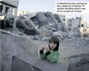  ??  ?? A Palestinia­n boy stands by the rubble of a Hamas TV station building which was hit by Israeli air strikes